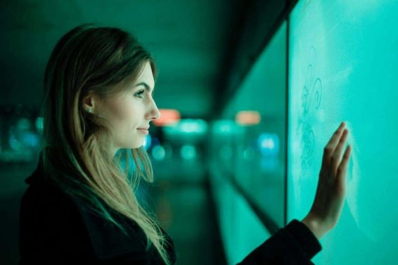 Close up side view of young woman against green wall