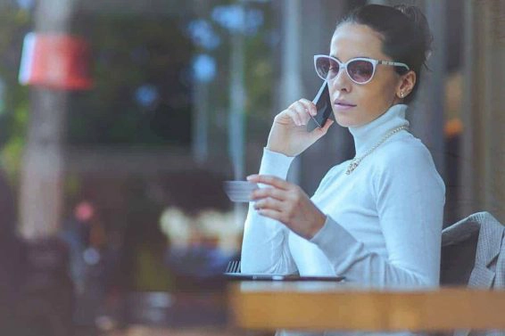 Young woman at cafe using credit card for online transaction