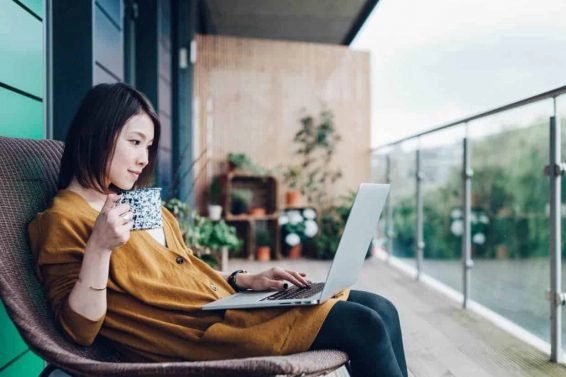 Young woman working on laptop in balcony