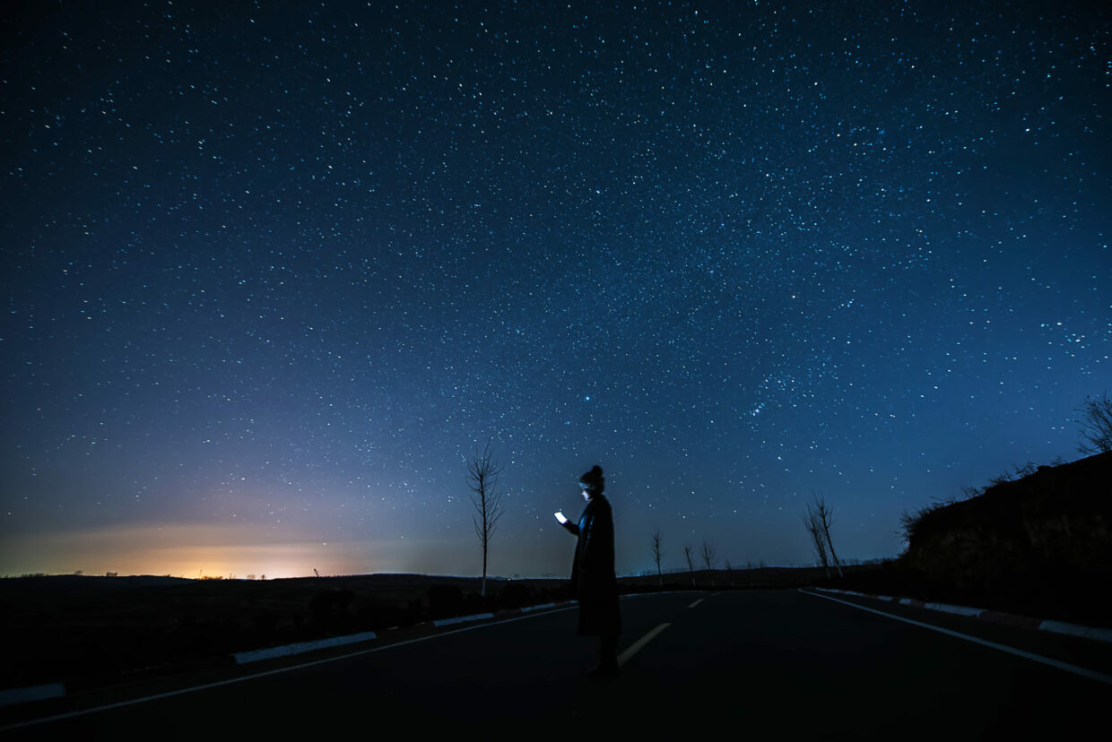 Girl using a mobile phone in starry night