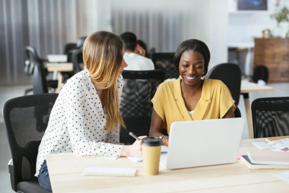 Colleagues working together at desk in office