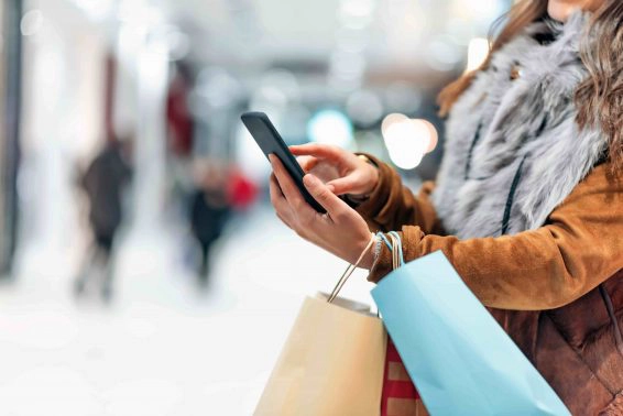 Woman using cellphone while shopping