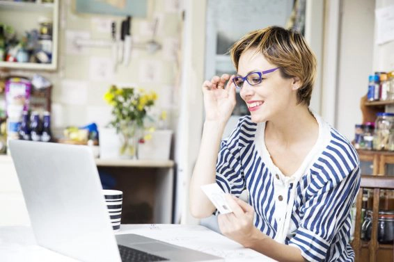 Mid adult woman online shopping in kitchen